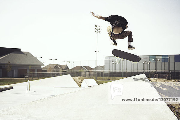 Junger Mann macht Stunts auf dem Skateboard