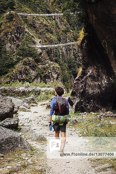 Rear view of hiker with backpack walking at Sagarmatha National Park