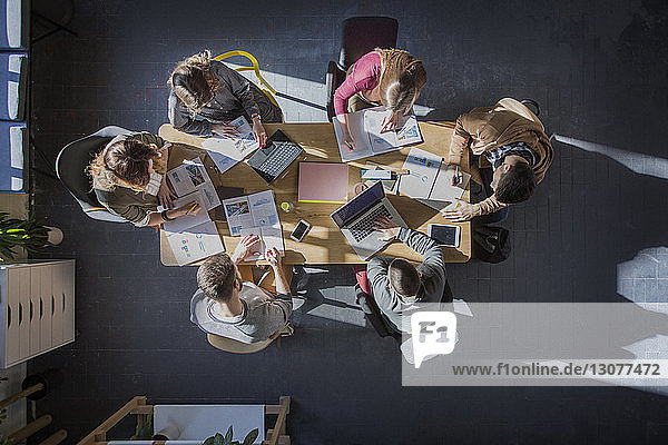 Overhead view of students studying at table in classroom