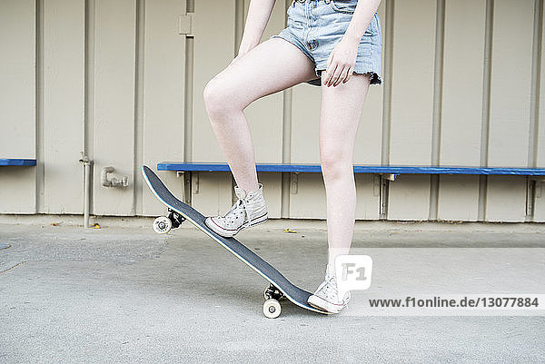 Niedriger Abschnitt eines Teenager-Mädchens beim Skateboarden im Park