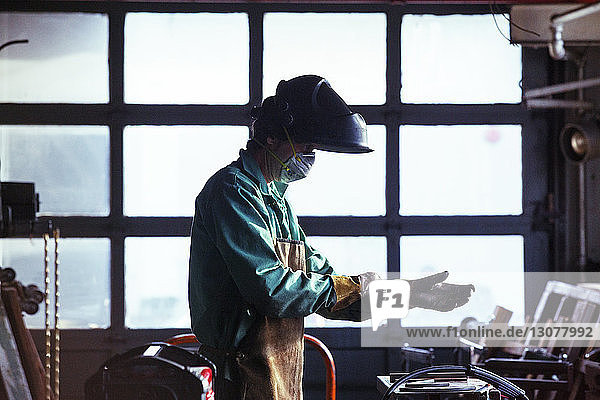 Mann trägt Arbeitsschutzkleidung in der Werkstatt