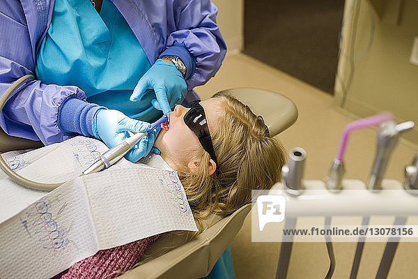 Zahnarzt untersucht Mädchen in Zahnarztpraxis