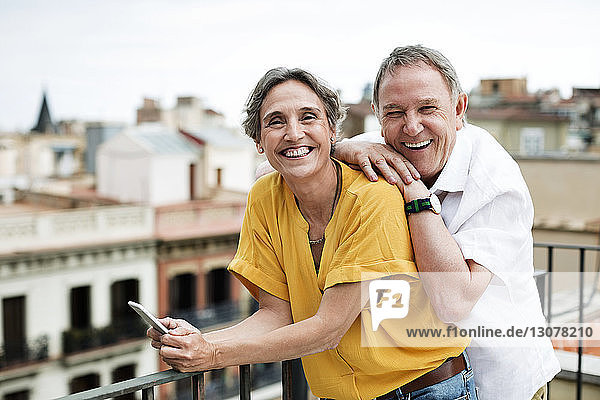 Porträt eines glücklichen älteren Paares auf der Terrasse stehend