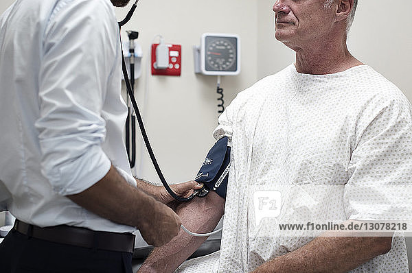 Mittelteil des Arztes  der den Blutdruck des Patienten im Krankenhaus überprüft
