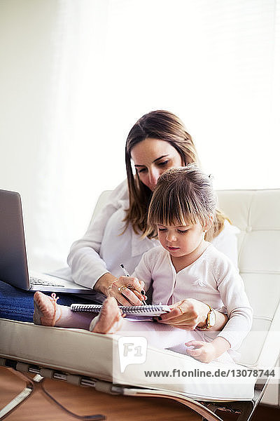 Mutter hilft Tochter beim Lernen zu Hause