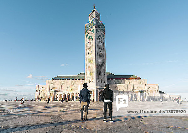 Rückansicht von Freunden  die sich gegen die Moschee Hassan II stellen