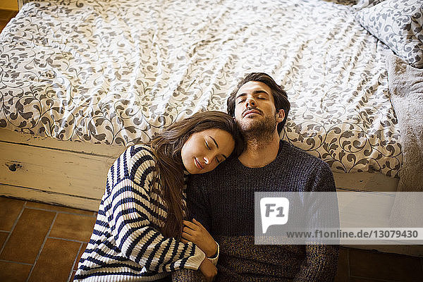 Paar ruht sich mit geschlossenen Augen aus  während es sich zu Hause an einen Fensterplatz in einer Nische lehnt
