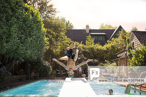 Boy jumping into swimming pool