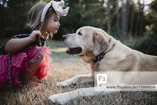Seitenansicht eines Mädchens beim Spielen mit Hund auf dem Feld
