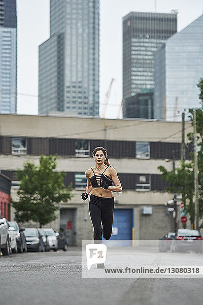 Sporty woman jogging on street in city
