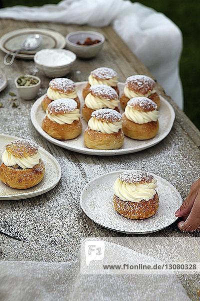 Cropped hand on person holding semla at table