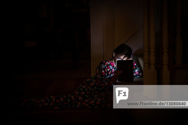 Mädchen benutzt Tablet-Computer in der Dunkelkammer zu Hause