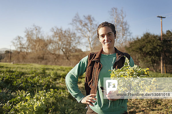 Porträt einer glücklichen Frau mit Blumen im Feld