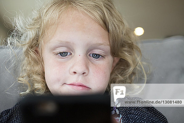 Niedrigwinkelansicht eines Mädchens mit Tablet-Computer am Bett zu Hause