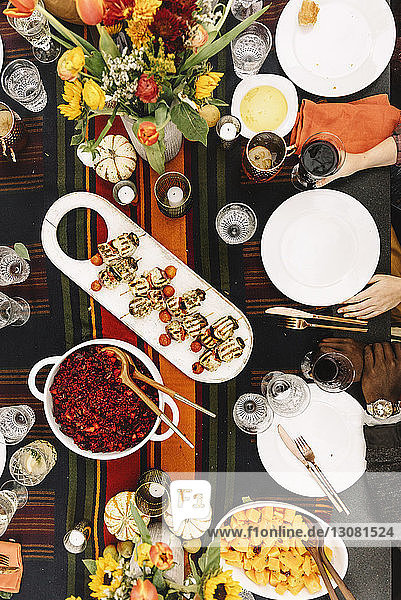 Ausgeschnittenes Bild von Freunden beim Essen mit Getränken am Tisch