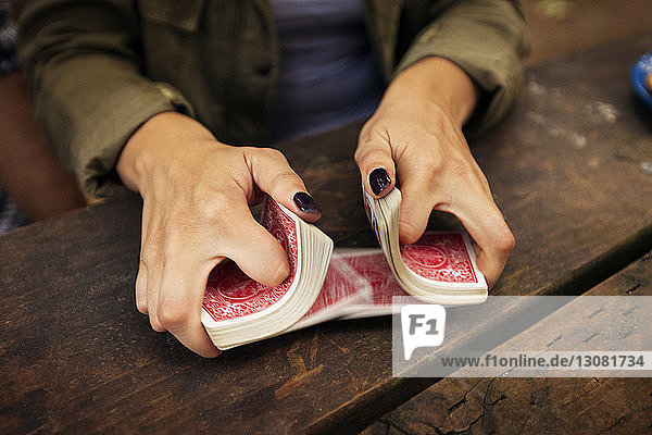 Ausgeschnittenes Bild einer Frau  die eine Spielkarte mischt