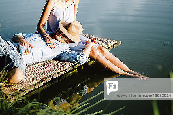 Freund entspannt sich auf dem Schoß der Freundin am See im Park