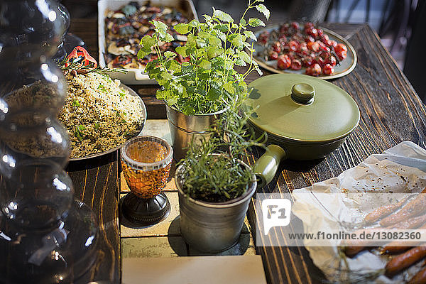 Schrägansicht auf verschiedene Speisen  die von Topfpflanzen auf dem heimischen Tisch serviert werden