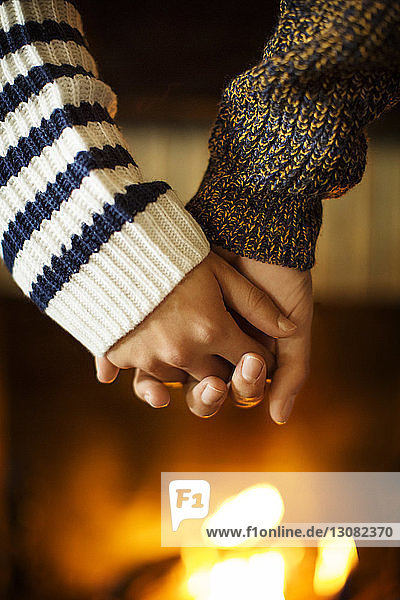 Ausgeschnittenes Bild eines Paares  das sich an der Feuerstelle an den Händen hält