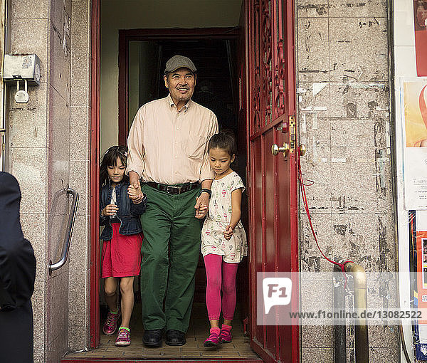 Großvater und Enkelkinder in voller Länge vor der Tür