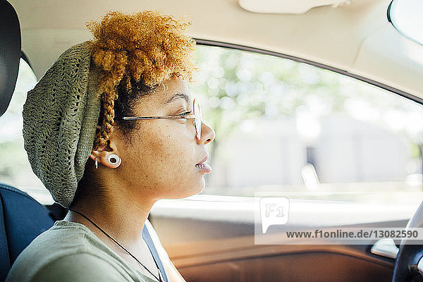 Seitenansicht einer nachdenklichen Frau  die im Auto sitzt