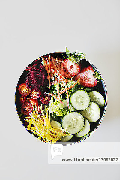 Draufsicht auf frischen Salat in Schüssel vor weißem Hintergrund