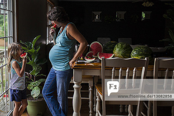 Mutter und Tochter essen Wassermelone zu Hause