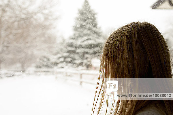Side view of girl looking at snowcapped