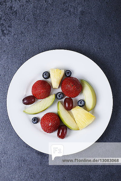 Draufsicht auf verschiedene frische Früchte in Tellerform auf dem Tisch