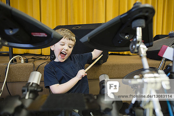 Verspielter Junge spielt Schlagzeug in der Grace Baptist Church