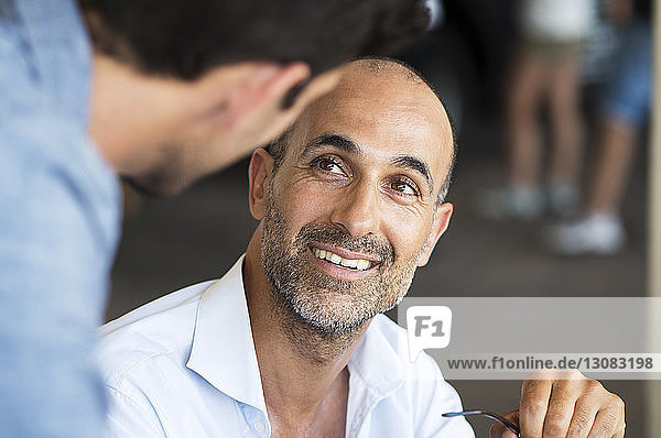 Close-up of businessman talking to colleague