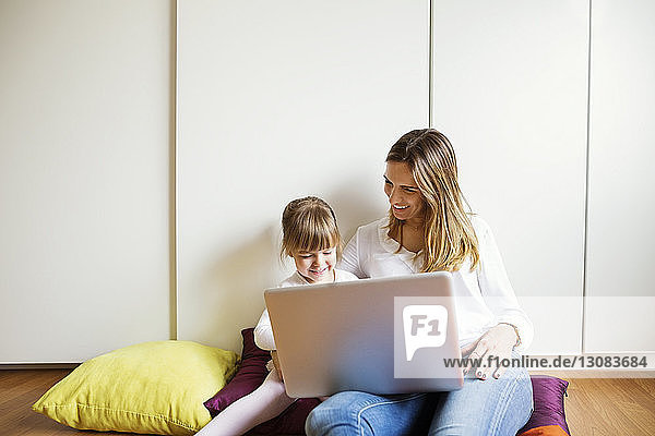 Glückliche Mutter und Tochter mit Laptop zu Hause