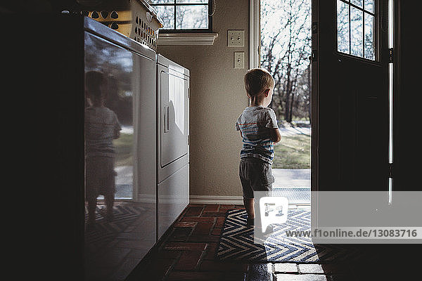 Rückansicht eines an der Tür stehenden Jungen mit Silhouette