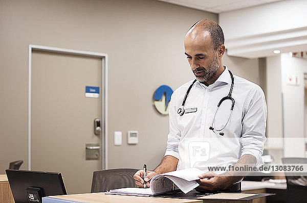 Doctor preparing reports while working in hospital