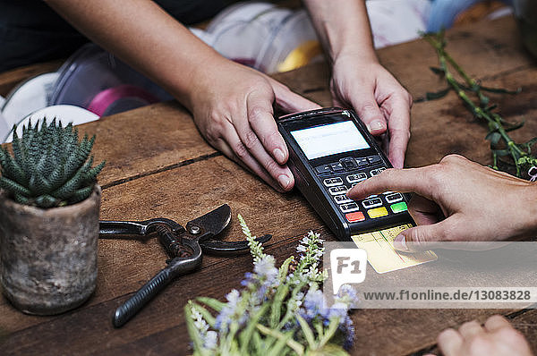 Ausgeschnittenes Bild eines Kunden  der mit Kreditkarte bezahlt
