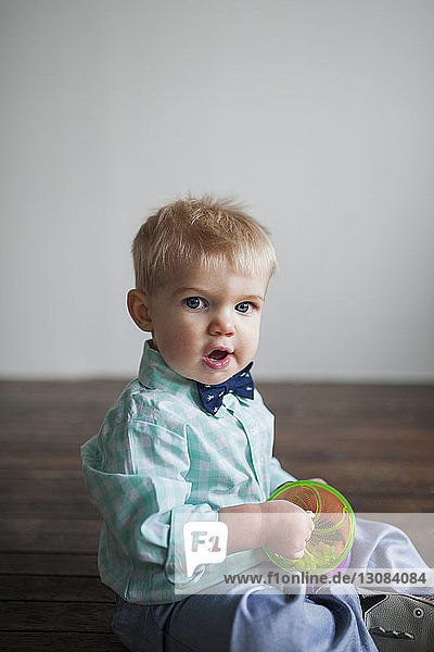Porträt eines süßen kleinen Jungen  der zu Hause auf dem Boden sitzt