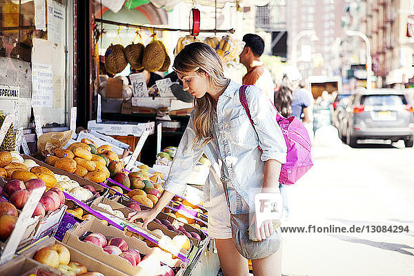 Frau wählt Äpfel am Marktstand an der Straße