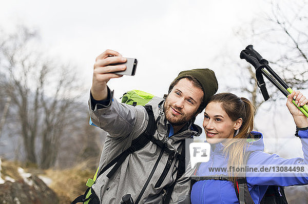 Hikers taking selfie on mountain during winter