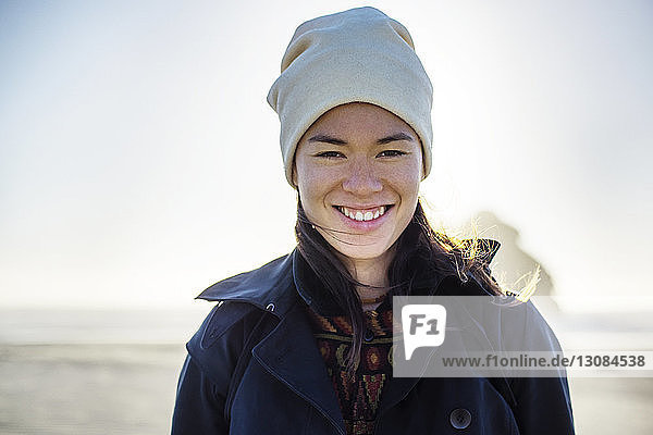 Porträt einer lächelnden Frau am Strand stehend