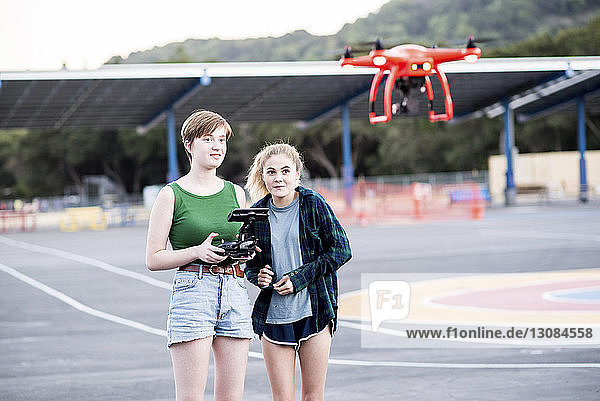 Freunde bedienen Quadcopter  während sie im Park stehen
