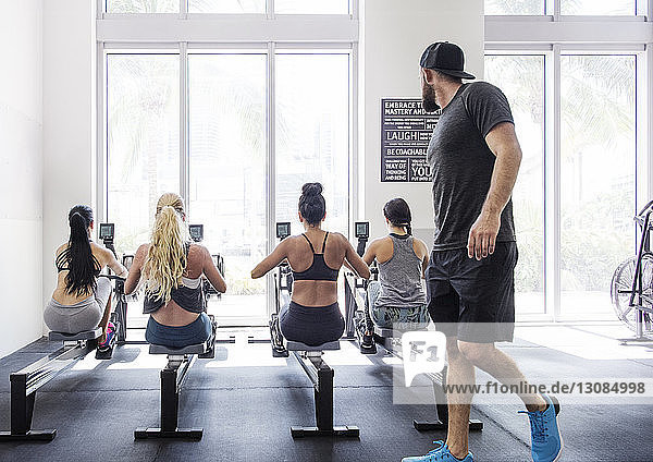 Ausbilder betrachtet Athleten  die im Crossfit-Fitnessstudio trainieren