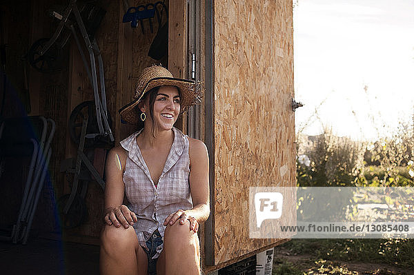 Glückliche Bäuerin sitzt in Hütte auf dem Feld