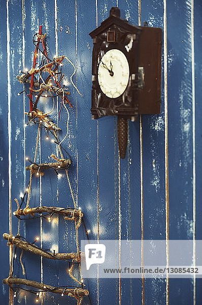 Weihnachtsschmuck hängt an blauer Holzwand