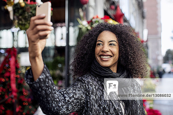 Woman taking selfie while standing on city street