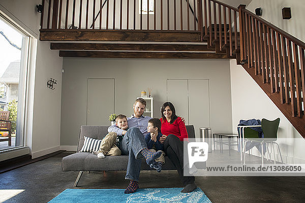Porträt einer Familie  die zu Hause auf dem Sofa sitzt