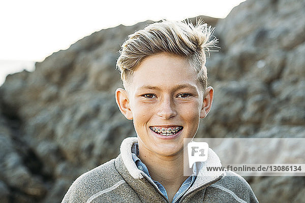 Portrait of smiling boy with braces at beach