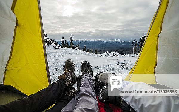 Niedrige Gruppe von Freunden rastet im Zelt auf schneebedecktem Berg