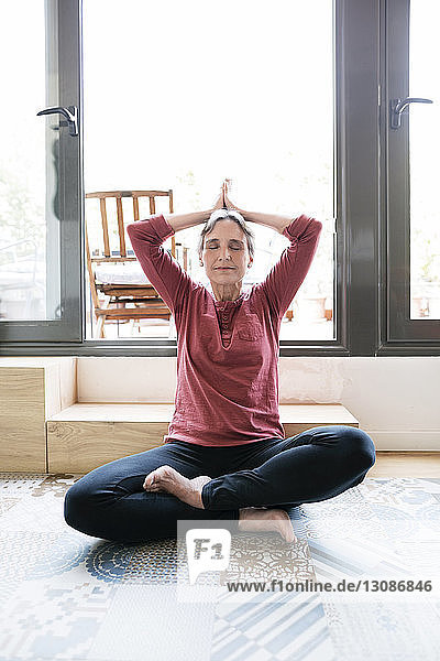 Mature woman doing yoga at home