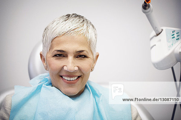 Portrait of smiling woman sitting on dentist's chair