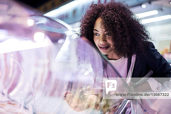 Frau betrachtet Vitrine beim Einkaufen auf dem Markt
